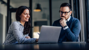 Man and woman in front of laptop on conference table