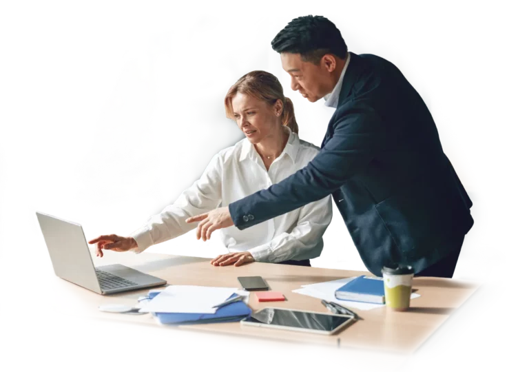 Business man and woman at cluttered desk pointing to laptop